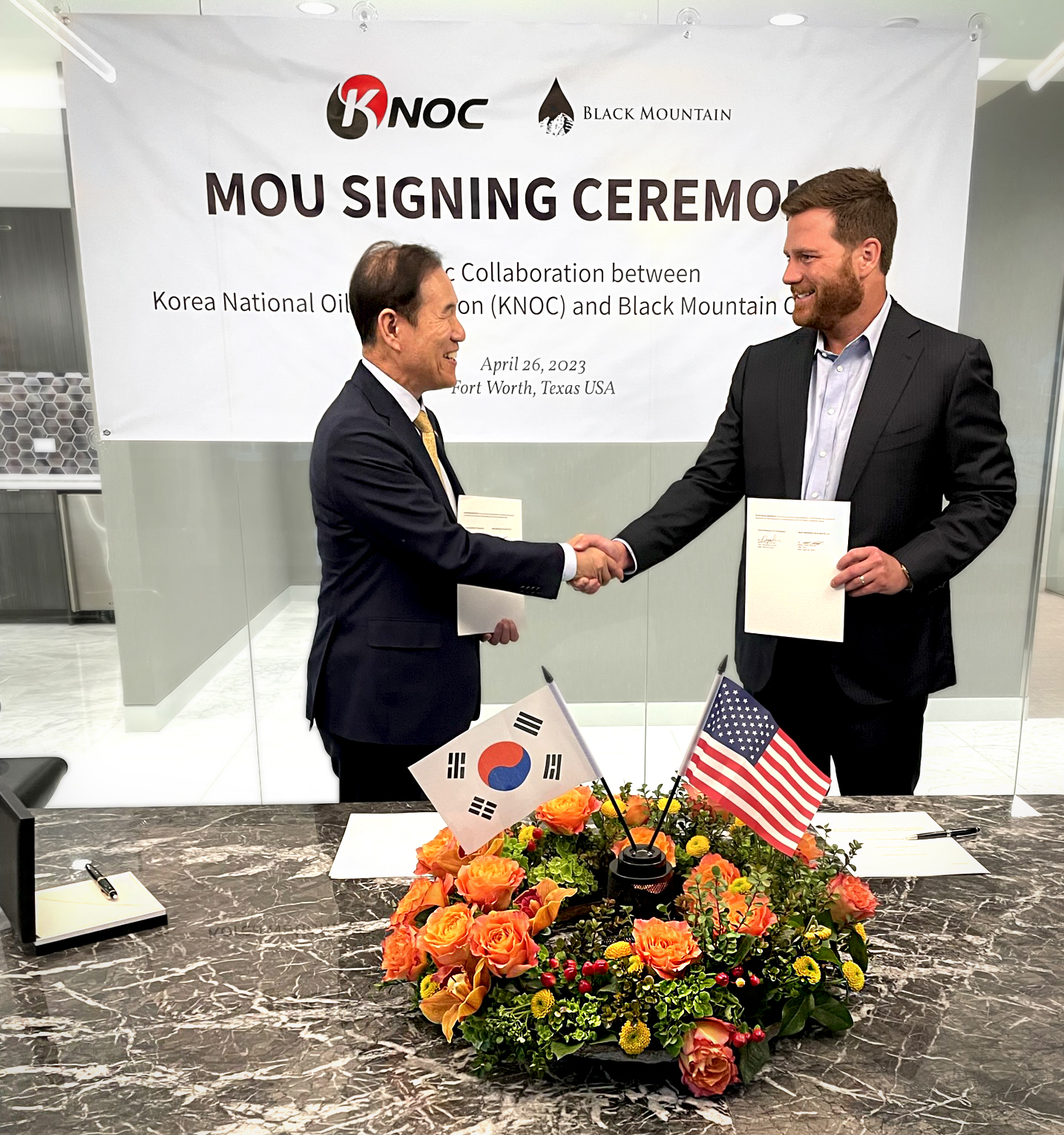 Black Mountain's Rhett Bennett and Korea National Oil Corporation's Dr. Dong S. Kim shake hands after signing a MOU for strategic collaboration between the companies.